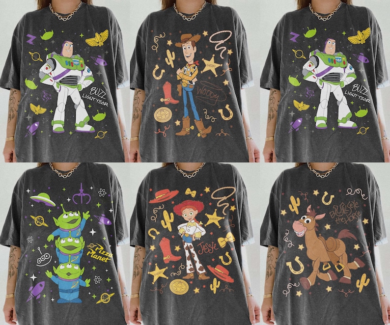 May include: Six dark gray t-shirts featuring Toy Story characters. Designs include Buzz Lightyear, Woody, Jessie, the Aliens, and Bullseye. Each shirt has colorful graphics and text, with a vintage, distressed look.