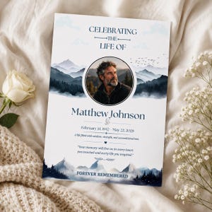 May include: A memorial card with a portrait of a man, mountains, and the text "Celebrating the Life of Matthew Johnson." The card includes dates, a quote, and the words "Forever Remembered."