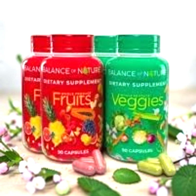 May include: Three supplement bottles with red and green lids. Two bottles are labeled "Fruits" and one is labeled "Veggies". The bottles are filled with capsules. The text "Balance of Nature" and "Dietary Supplement" are also visible.