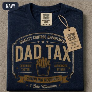 May include: A navy blue t-shirt with a tan graphic print that reads "QUALITY CONTROL DEPARTMENT DAD TAX CERTIFIED TASTER AUTHORIZED BY DAD SAMPLING REQUIRED 1 Bite Minimum" featuring a french fry container icon and a branded paper hang tag.