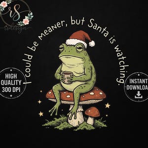 May include: A graphic illustration of a green frog wearing a red and white Santa hat, sitting on a large spotted mushroom while holding a small mug. The text "I could be meaner, but Santa is watching" arches over the frog, with small stars.