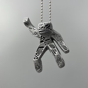 Rocky keychain inspired by Project Hail Mary hanging beside keyboard as cute alien accessory
