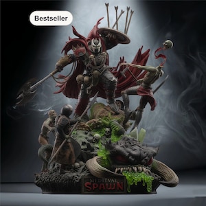 Puede incluir: Estatua detallada de Medieval Spawn en batalla, con capa roja, armadura y arma. La base incluye un monstruo, calaveras y el texto "MEDIEVAL SPAWN". La estatua es un éxito de ventas.