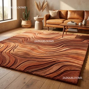 May include: A rectangular, textured rug with a wave-like pattern in shades of brown and orange. The rug is placed on a hardwood floor, and the design creates a sense of depth and movement. The rug is a home decor item.