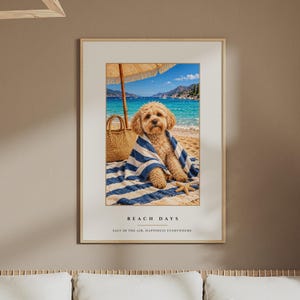 Pode incluir: Uma impressão artística emoldurada com um cão de pelo claro enrolado numa toalha às riscas azuis e brancas numa praia de areia. A cena inclui um saco de palha, um guarda-sol e uma estrela-do-mar. O texto diz BEACH DAYS e SALT IN THE AIR, HAPPINESS EVERYWHERE.