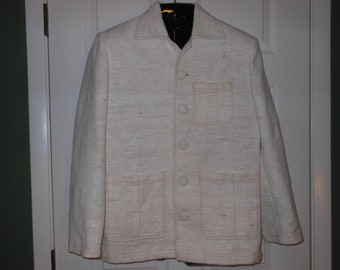 May include: A white linen jacket with a button-up front and two large pockets. The jacket has a light pink stitching detail around the pockets and collar.