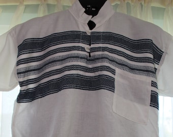 May include: A white short-sleeved shirt with a black and white striped pattern around the chest. The shirt has a button-up collar and a single button closure.