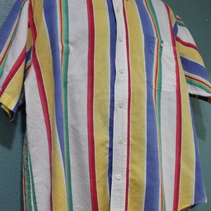 May include: A short-sleeved button-down shirt with a striped pattern in yellow, red, blue, and green.