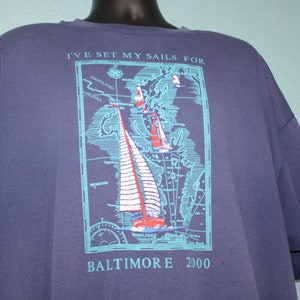 May include: A navy blue t-shirt with a graphic of a map of the Chesapeake Bay and the text "I've set my sails for Baltimore 2000".