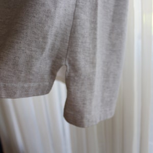 May include: A gray t-shirt with a side seam detail. The t-shirt is made of a soft, comfortable fabric.