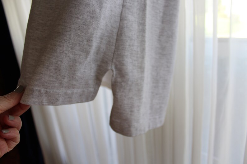 May include: A gray t-shirt with a side seam detail. The t-shirt is made of a soft, comfortable fabric.
