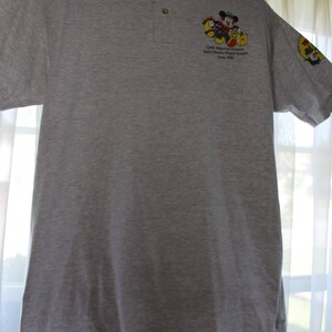 May include: A gray polo shirt with a Mickey Mouse graphic and the text "12th Annual Imperial Senators Walt Disney World Resort June 1998".
