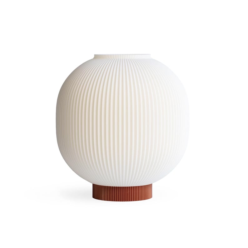 May include: A white, ribbed, spherical lamp with a cylindrical, reddish-brown base. The lamp has a rounded shape and a textured surface. The design is modern and minimalist, suitable for home decor.