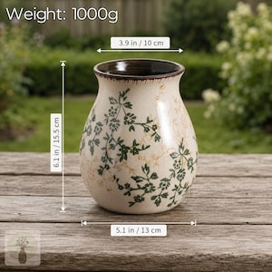 May include: A cream-colored ceramic vase with a dark brown rim and a green floral pattern. The vase has a weight of 1000g, a height of 6.1 inches, a top diameter of 3.9 inches, and a base width of 5.1 inches, featuring a visible crackle glaze finish.