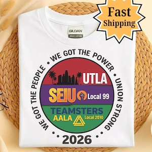 May include: White t-shirt with a circular graphic featuring text and logos. The graphic includes the words "WE GOT THE POWER", "UTLA", "SEIU Local 99", "TEAMSTERS AALA", and the year "2026". A "Fast Shipping" sticker is in the top right corner.