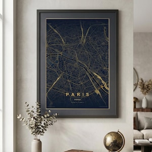 May include: Framed map of Paris, France, in a dark blue and gold colour scheme. The map details the city's streets and landmarks. The word "PARIS" is displayed in gold lettering. The framed map is displayed on a white wall.