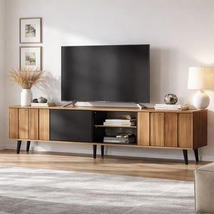 Könnte beinhalten: Ein TV-Schrank im Mid-Century-Modern-Stil mit einem großen schwarzen Fernsehbildschirm. Der Schrank ist aus Holz mit natürlicher Oberfläche und schwarzen Akzenten gefertigt. Er hat Türen und offene Regale zur Aufbewahrung.