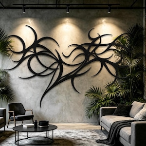 Può includere: Una grande opera d'arte da parete in metallo nero caratterizzata da linee complesse, fluide e curve che creano un motivo astratto e organico. La scultura è montata su una parete in cemento grigio testurizzato, illuminata da faretti in un soggiorno.