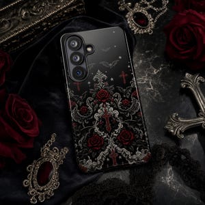 May include: A black smartphone case featuring a detailed pattern of red roses, white ornate filigree, small crosses, and flying bats against a dark background. The case has a triple camera cutout on the upper left side and a smooth, glossy finish.