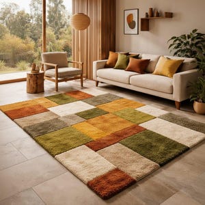 Könnte beinhalten: Ein rechteckiger Teppich mit einem Patchwork-Design in Orange-, Grün-, Beige- und Gelbtönen. Der Teppich befindet sich in einem Wohnzimmer mit Sofa, Sessel und Zierkissen. Der Raum hat eine neutrale Farbpalette.