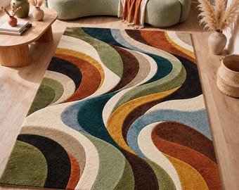 Peut inclure: Un tapis rectangulaire présentant un motif répétitif de grandes formes courbes en forme de vagues dans des tons de vert olive, orange brûlé, bleu sarcelle profond, jaune moutarde, brun foncé et crème, créant un effet visuel superposé.