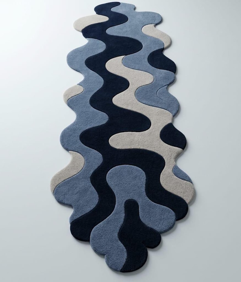 Pode incluir: Um tapete passadeira longo e estreito com uma forma org&acirc;nica ondulada e um padr&atilde;o em camadas de curvas entrela&ccedil;adas. O design consiste em blocos de cores s&oacute;lidas em azul-marinho profundo, azul-ard&oacute;sia m&eacute;dio e bege claro fluido.