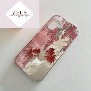 May include: Clear phone case with a pink and white design featuring two goldfish and pink floral accents. The case has a glossy finish. The Zeus Accessories logo is in the upper left corner. The design is decorative.