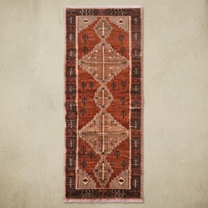 May include: A rectangular runner rug featuring a deep rust-orange background with a series of stacked, light brown diamond-shaped geometric patterns. The border is dark brown with small, repeating tree-like motifs and light-coloured diamond accents.