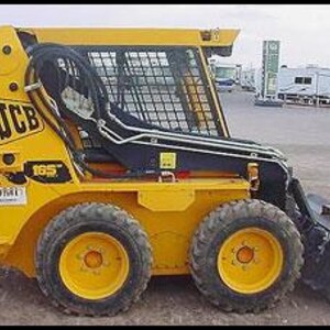 Può includere: Un caricatore skid steer JCB 165 giallo con dettagli neri. Il caricatore ha un attacco a benna, una gabbia protettiva e quattro pneumatici neri con cerchi gialli. Il logo JCB è visibile sul lato.