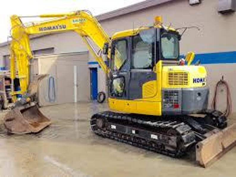 May include: A yellow Komatsu excavator with a black undercarriage and a silver bucket. The excavator is parked on a concrete surface. The Komatsu logo is visible on the side of the cab.