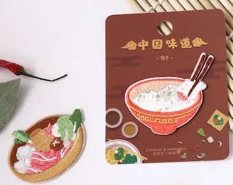 Könnte beinhalten: Zwei gestickte Bügelbilder mit chinesischem Essen. Ein Patch zeigt eine Schüssel Reis mit Stäbchen, der andere zeigt einen Hot Pot mit Gemüse und Fleisch. Die Karte lautet "Chinesische Aromen - Ein Bissen".