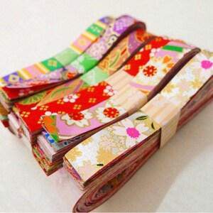 May include: A stack of colorful washi tape rolls with floral and geometric patterns. The tape is made of Japanese paper and is perfect for adding a touch of whimsy to crafts, gifts, and home decor.