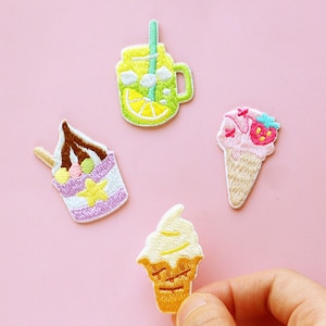 Puede incluir: Cuatro parches bordados para planchar con motivos de delicias de verano: un vaso de limonada, una copa de helado y dos conos de helado.