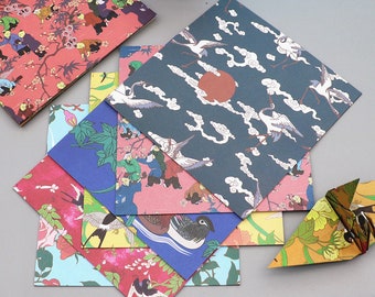May include: A selection of patterned paper envelopes with diverse designs. The envelopes showcase illustrations of cranes, clouds, and figures in traditional Asian art styles. Colours include red, blue, green, and orange. An origami bird is also present.