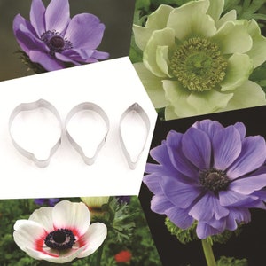 Könnte beinhalten: Drei Metall-Ausstecher in Form von Anemonenblütenblättern. Die Ausstecher sind silberfarben und haben eine glatte, polierte Oberfläche.