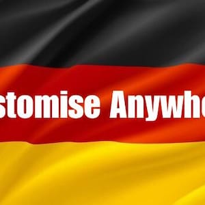 Könnte beinhalten: Eine Stoffflagge mit horizontalen Streifen in Schwarz, Rot und Gold. Der Text "Customise Anywhere" ist in fetten, weißen Großbuchstaben auf dem mittleren roten Streifen aufgedruckt, wobei der Stoff weiche, fließende Falten aufweist.