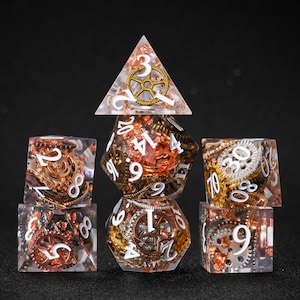 May include: A set of seven polyhedral dice with a steampunk theme. The dice are clear with copper, gold, and silver gears and white numbering. The set includes a D4, D6, D8, D10, D12, D20, and a D%.