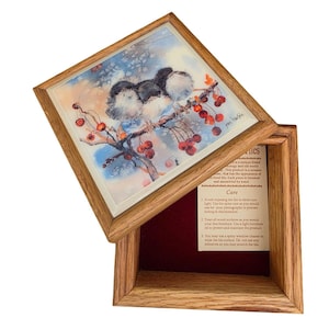 May include: A square wooden box with a removable lid featuring a ceramic tile insert. The tile displays a watercolor illustration of three small birds perched on a branch with red berries. The interior base is lined with dark red velvet fabric.