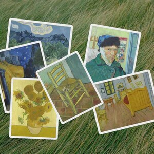 Può includere: Una collezione di sei biglietti d'arte con dipinti famosi di Vincent van Gogh. I biglietti raffigurano scene come girasoli, una camera da letto e autoritratti, tutti con bordi bianchi, disposti su erba verde.