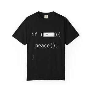 Peut inclure: T-shirt noir avec texte blanc. Le texte, écrit dans un style de code de programmation, se lit "if (Shift) { peace(); }". Le t-shirt a un col rond et des manches courtes.