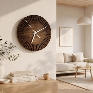 May include: A circular wooden wall clock in a dark brown hue. The clock has a sunburst pattern around the edge and white hands. It is mounted on a light-coloured wall.