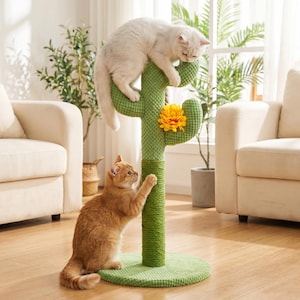 May include: A green cactus-shaped cat scratching post with a yellow flower and two cats. One cat is white and perched on top, while the other is orange and reaching up the post. The post has a round base and is in a living room setting.