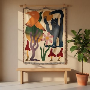 Peut inclure: Une tapisserie murale tissée sur fond crème avec un motif graphique coloré. L'illustration présente un grand oiseau orange, une créature bleu foncé tenant un soleil jaune, une fleur rose et plusieurs formes rappelant des champignons rouges et violets.