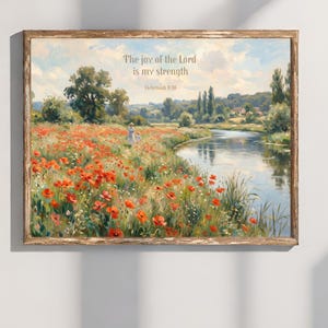 Puede incluir: Pintura de paisaje enmarcada con un campo de amapolas rojas, un río y un cielo azul. La obra de arte incluye el texto "El gozo del Señor es mi fortaleza" de Nehemías 8:10. Una mujer y un niño caminan a lo lejos.