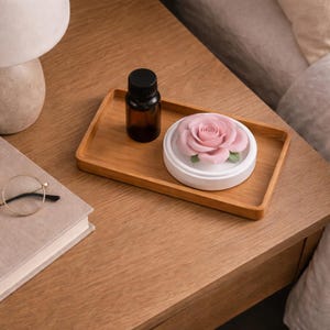 May include: A white ceramic mug with a black handle and the text "But First, Coffee" in a handwritten style. The mug is on a white surface. The mug is 10 cm tall.