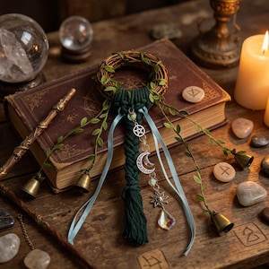 May include: A mystical arrangement with a crystal ball, candles, and a decorative wreath with charms. A wand, bells, and a vintage book are on a wooden surface. The scene is illuminated with warm, inviting light.