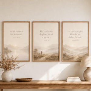 Puede incluir: Tres cuadros verticales enmarcados con paisajes en tonos beige y marrón claro que muestran montañas y agua. Cada lámina presenta texto religioso: Be still and know that I am God, The Lord is my shepherd, I shall not want y For I know the plans I have for you.