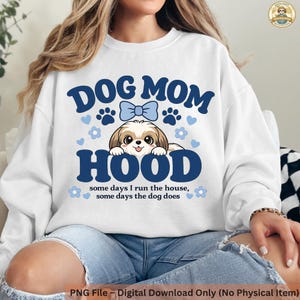 Könnte beinhalten: Weißes Sweatshirt mit dem blauen Text "DOG MOM HOOD", mit einem Cartoon-Shih Tzu-Hund und Pfotenabdrücken. Der Text "some days I run the house, some days the dog does" ist ebenfalls enthalten.