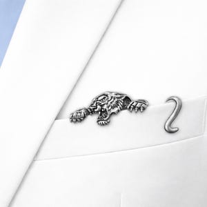 May include: A set of three ceramic mugs with a speckled, matte finish in cream, light grey, and dark grey. Each mug has a simple, minimalist design and a rounded handle. The mugs are stacked on top of each other.