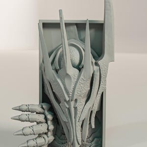 May include: A light grey, 3D-printed wall art piece with an abstract, stylised design. The artwork features sharp, elongated elements and a detailed, textured surface. The design has a central, organic shape with a claw-like appendage.